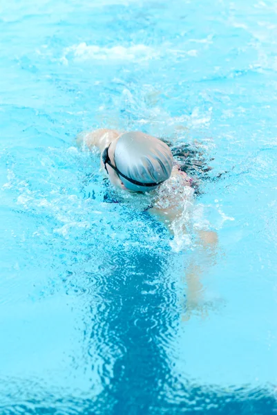 Giovane donna nuotare sulla piscina coperta primo piano. modalità stile libero . — Foto Stock