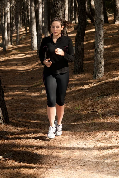 Giovane donna che corre su boschi, sfondo esterno — Foto Stock