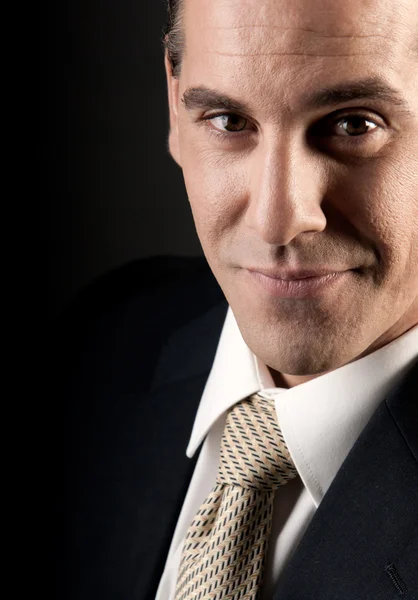 Adult businessman close-up portrait smiling on dark background. — Stock Photo, Image