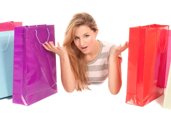 Mujer joven con bolsas de compras tumbadas en el suelo sobre fondo blanco —  Fotos de Stock
