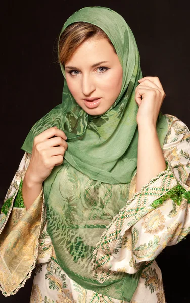 Молода арабська жінка з вуаллю стоїть на темному тлі — стокове фото