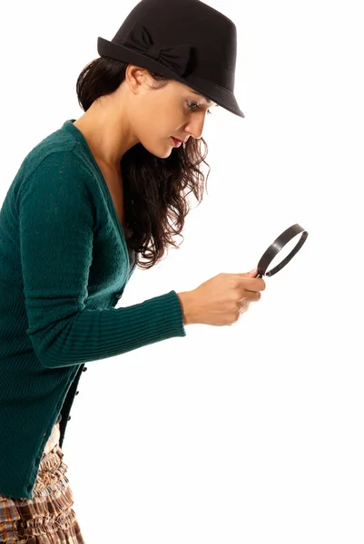年轻女子用放大镜玻璃和帽子寻找的东西上孤立 — 图库照片