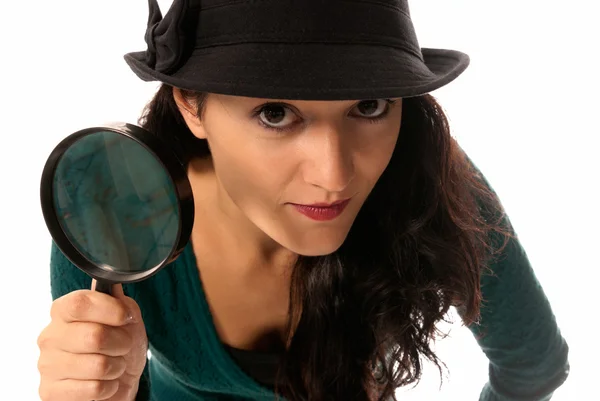 Jonge vrouw met Vergrootglas glas en hoed op zoek naar camera geïsoleerd op whit — Stockfoto