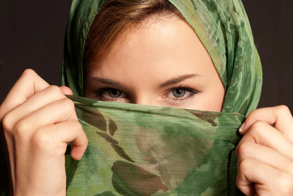 Fiatal arab nő, fátyol mutatja a szemét sötét szürke háttér — Stock Fotó