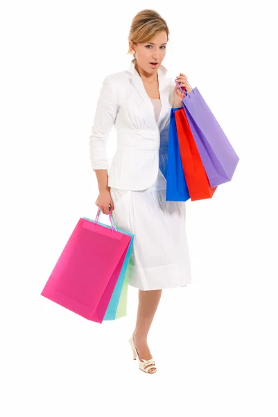 Mladá žena s nákupní tašky stojící izolovaných na bílém pozadí — Stock fotografie