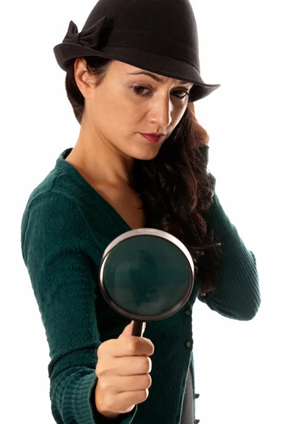 Młoda kobieta z szkło powiększające i kapelusz Szukam coś na tle — Zdjęcie stockowe