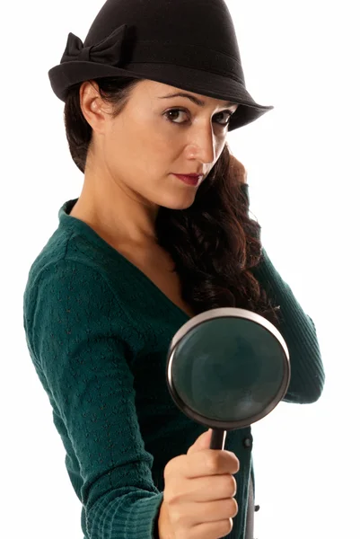 Молодая женщина с увеличительным стеклом и шляпой, смотрящая в камеру изолированы на Уит — стоковое фото