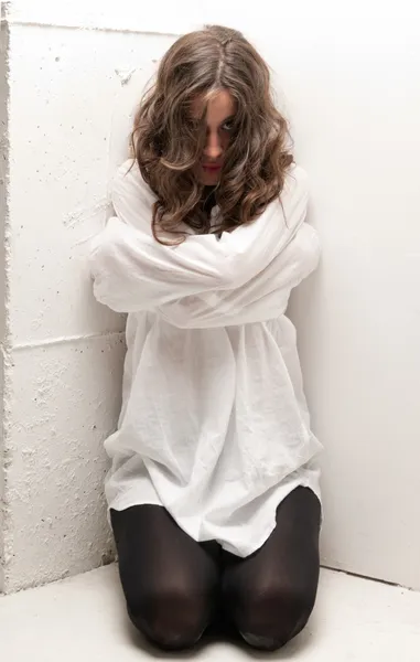 Young insane woman with straitjacket on knees looking at camera — Stock Photo, Image