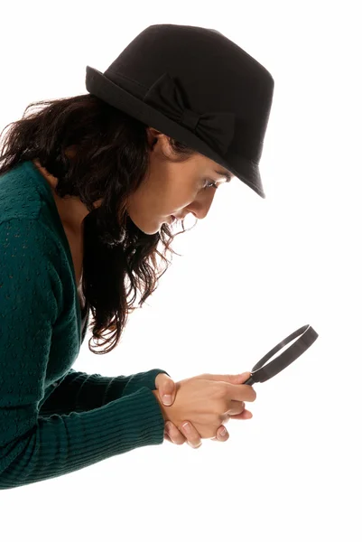 Giovane donna con lente di ingrandimento in vetro e cappello alla ricerca di qualcosa di isolato su — Foto Stock