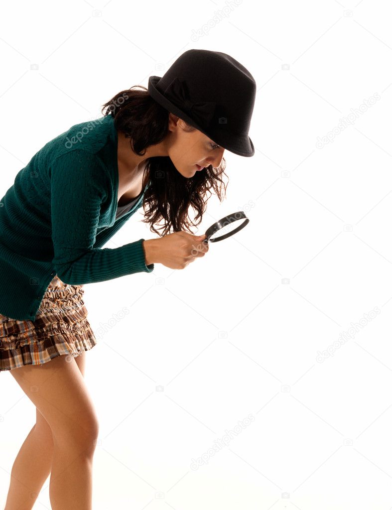 Young woman with magnifier glass and hat looking for something isolated on