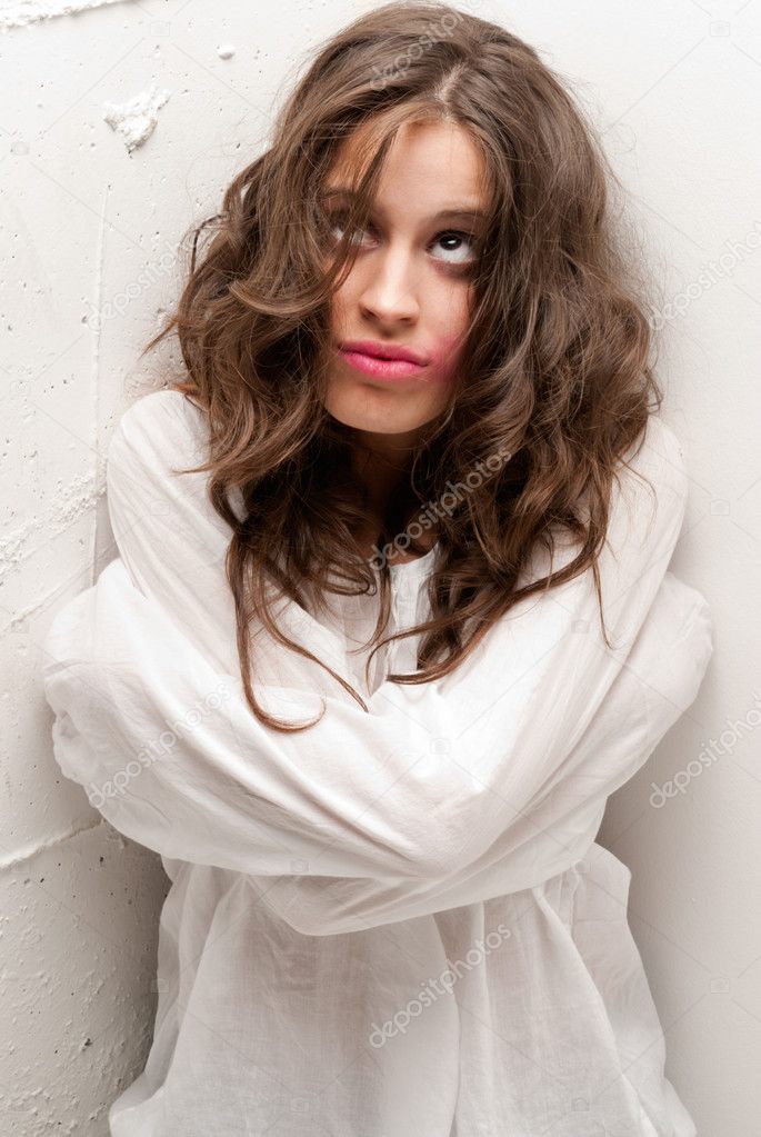 Young insane woman with straitjacket looking up camera close-up portrait