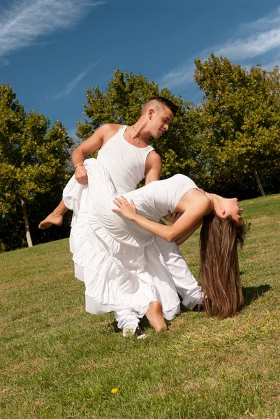 Jovem bela dança casal e abraçar na grama sobre o céu — Fotografia de Stock