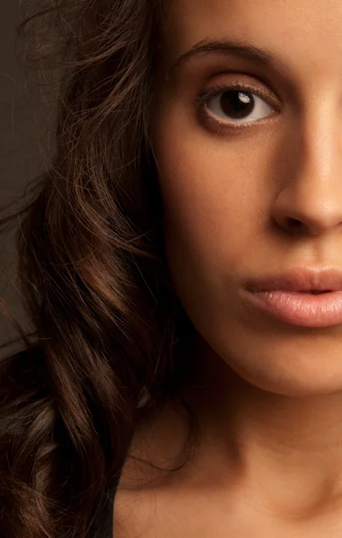 Jovem mulher close-up retrato metade rosto no fundo escuro — Fotografia de Stock