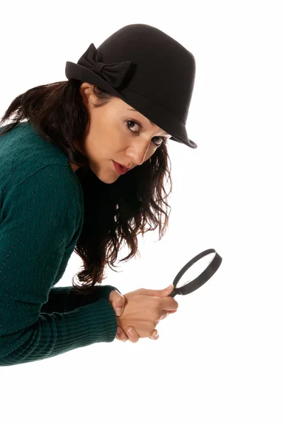 Mujer joven con lupa y sombrero mirando a la cámara aislada en whit — Foto de Stock