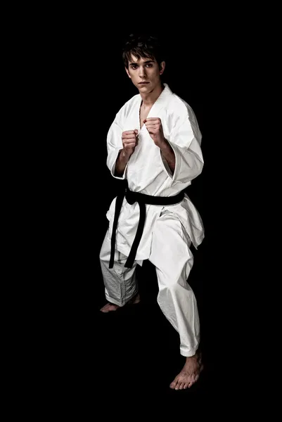 Karate fighter mężczyzna młody wysoki kontrast na czarnym tle. — Zdjęcie stockowe