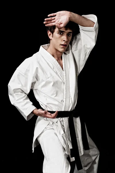 Karate muž bojovník mladých vysoký kontrast na černém pozadí. — Stock fotografie