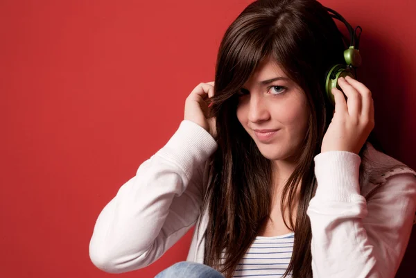 Menina Ouvindo Música Com Fones Ouvido Uma Parede Vermelha — Fotografia de Stock
