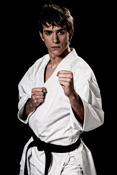 Karate erkek avcı genç yüksek karşıtlık siyah arka plan üzerine.