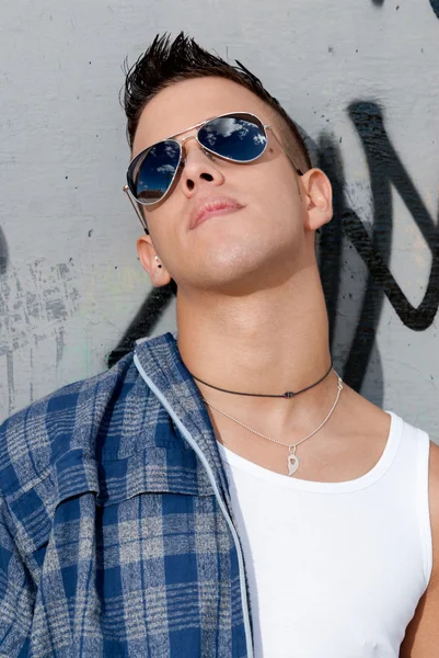 벽에 선글라스에 젊은 남성 도시 패션 하늘 스톡 사진