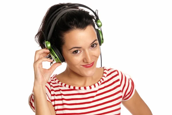 Mujer joven escuchando música con auriculares aislados sobre fondo blanco Fotos de stock libres de derechos
