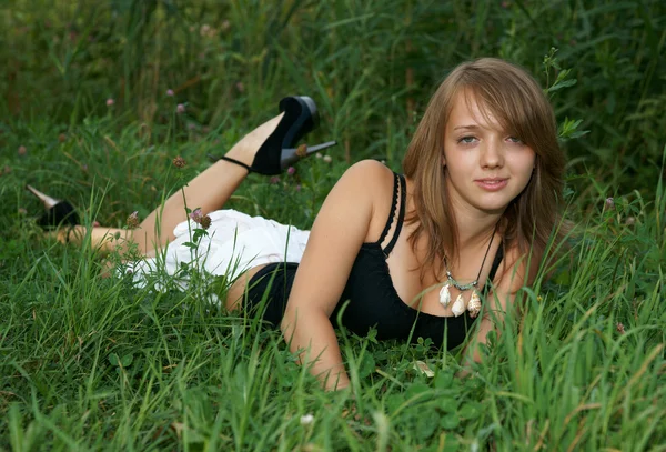 Το όμορφο κορίτσι σε ένα πράσινο γρασίδι — Φωτογραφία Αρχείου