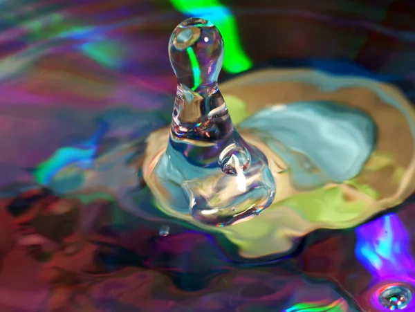 Csepp víz multi színes háttérrel — Stock Fotó