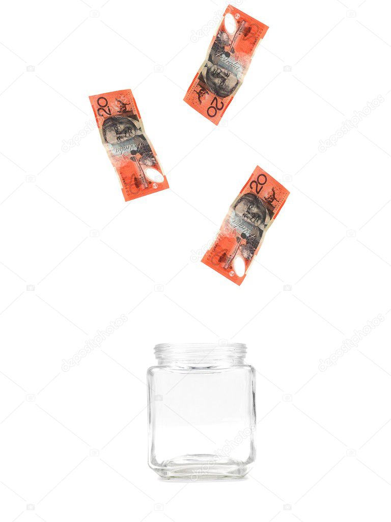 Australian twenty dollar notes floating into a jar isolated against a white background