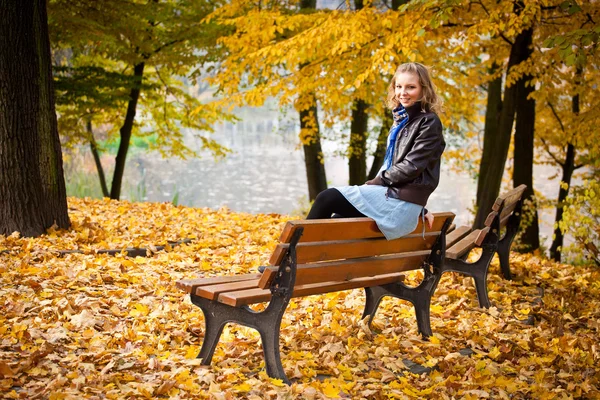 Young caucasian student girl in golden autumn park — Stock Photo, Image