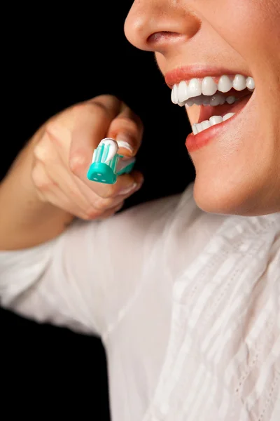 Γυναίκα closeup υγιή δόντια με οδοντόβουρτσα σε μαύρο φόντο — Φωτογραφία Αρχείου