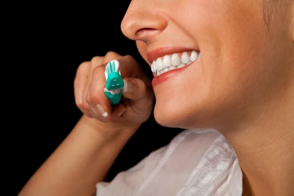 Mujer sana dientes primer plano con cepillo de dientes sobre fondo negro —  Fotos de Stock