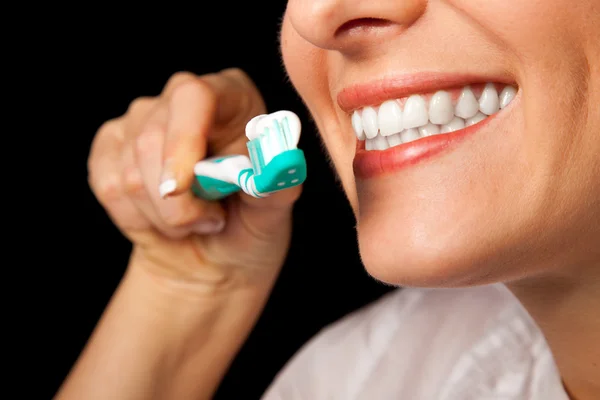 Mulher dentes saudáveis closeup com escova de dentes no fundo preto — Fotografia de Stock