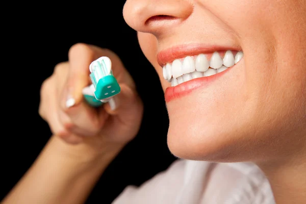 Frau gesunde Zähne Nahaufnahme mit Zahnbürste auf schwarzem Hintergrund — Stockfoto