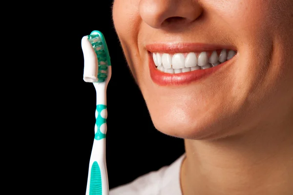 Woman healthy teeth closeup with toothbrush on black background — Stock Photo, Image
