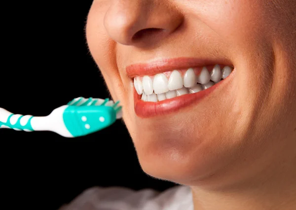 Kvinna friska tänder närbild med tandborste på svart bakgrund — Stockfoto