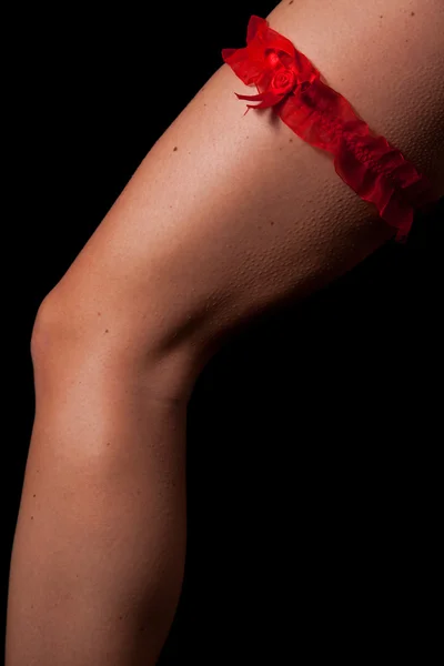Siyah zemin üzerine kırmızı eşarp ile kadın bacak — Stok fotoğraf