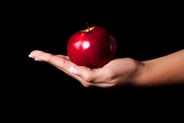 Femme main donnant une pomme à l'homme sur fond noir — Photo