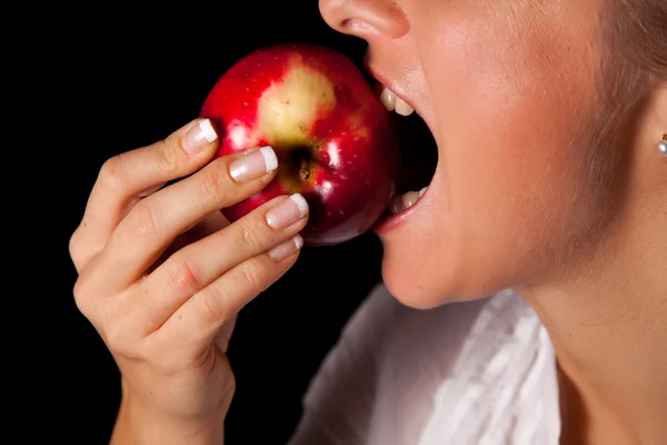 Mulher segurando maçã vermelha no fundo preto — Fotografia de Stock