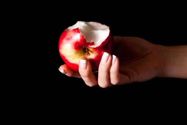 Mulher mão dando uma maçã para o homem no fundo preto — Fotografia de Stock