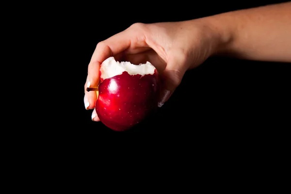 Женщина рука дарит яблоко мужчине на черном фоне — стоковое фото