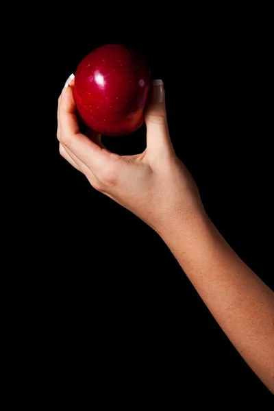 Vrouw hand geven een appel aan de mens op zwarte achtergrond Stockfoto