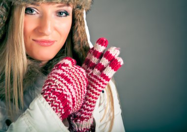 Portret van mooie blonde vrouw in warme kleren op blauwe achtergrond