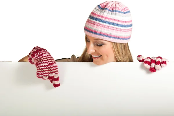 Femme en chapeau coloré et gants peeping de derrière tableau blanc isolé sur — Photo