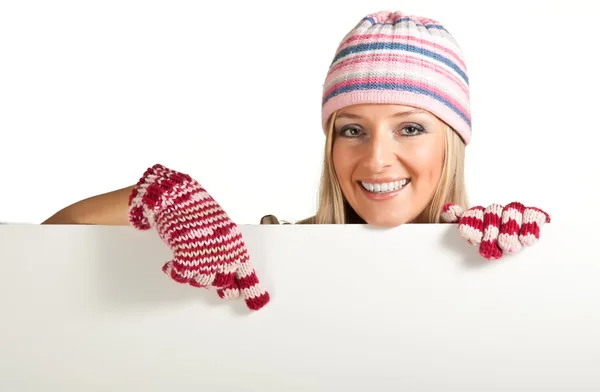 Žena v barevné čepici a rukavice, vykukující zpod tabule izolovaných na — Stock fotografie