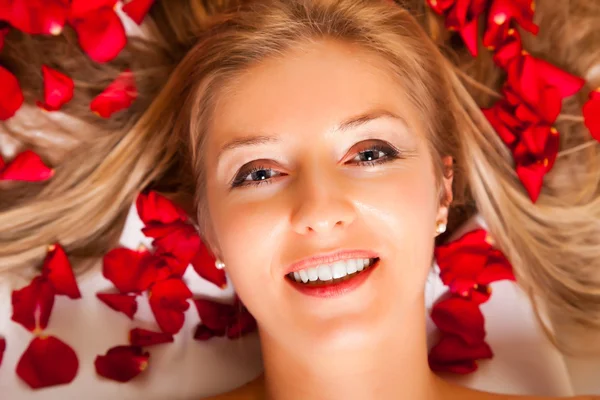 バラの花びらの髪に敷設白人の女性の肖像画 — ストック写真