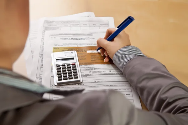 Vrouw Hand Invullen Van Inkomstenbelasting Formulieren Met Calculator — Stockfoto