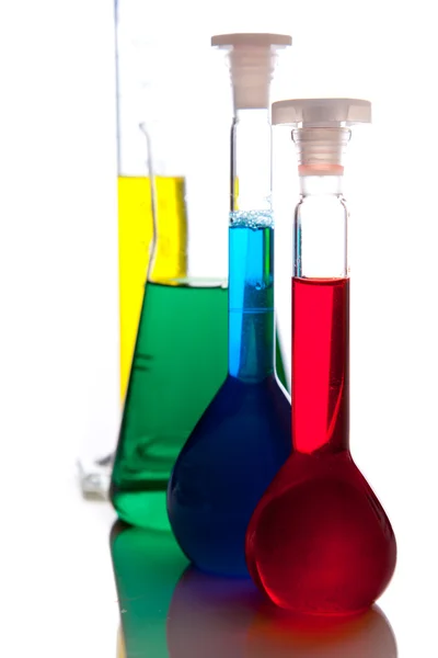 Objectos de vidro para laboratório com fluidos coloridos isolados a branco — Fotografia de Stock