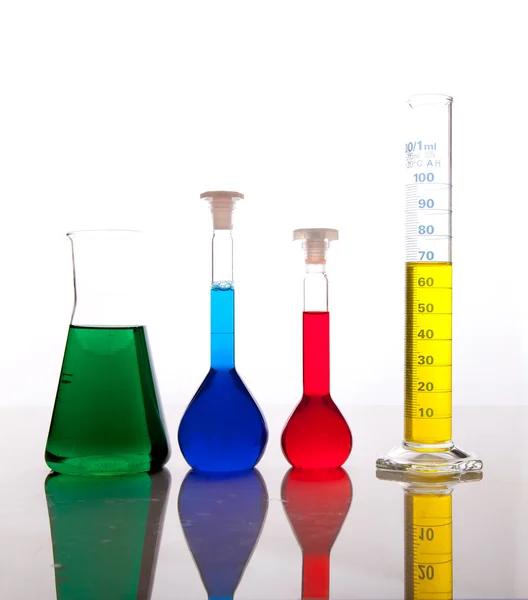 Objectos de vidro para laboratório com fluidos coloridos isolados a branco — Fotografia de Stock