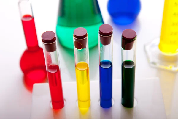 Лабораторное стекло с красочными жидкостями, изолированными на белом — стоковое фото