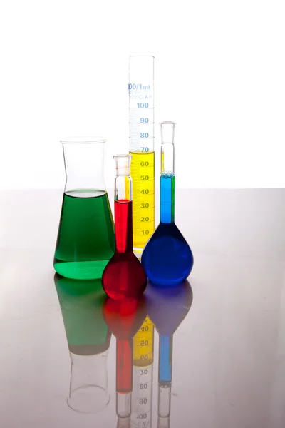 Verrerie labolatoire avec fluides colorés isolés sur blanc — Photo