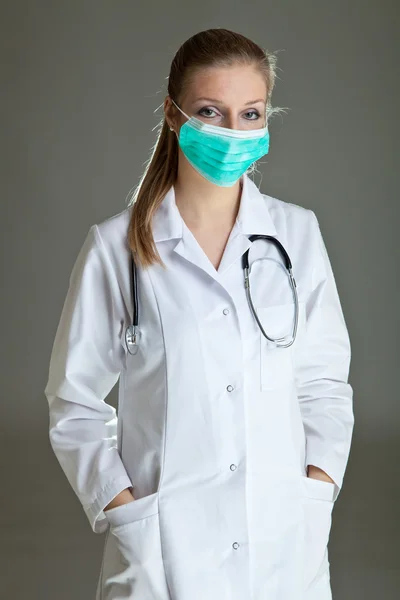 Orvos nő egyenruhában semleges szürke sztetoszkóp — Stock Fotó